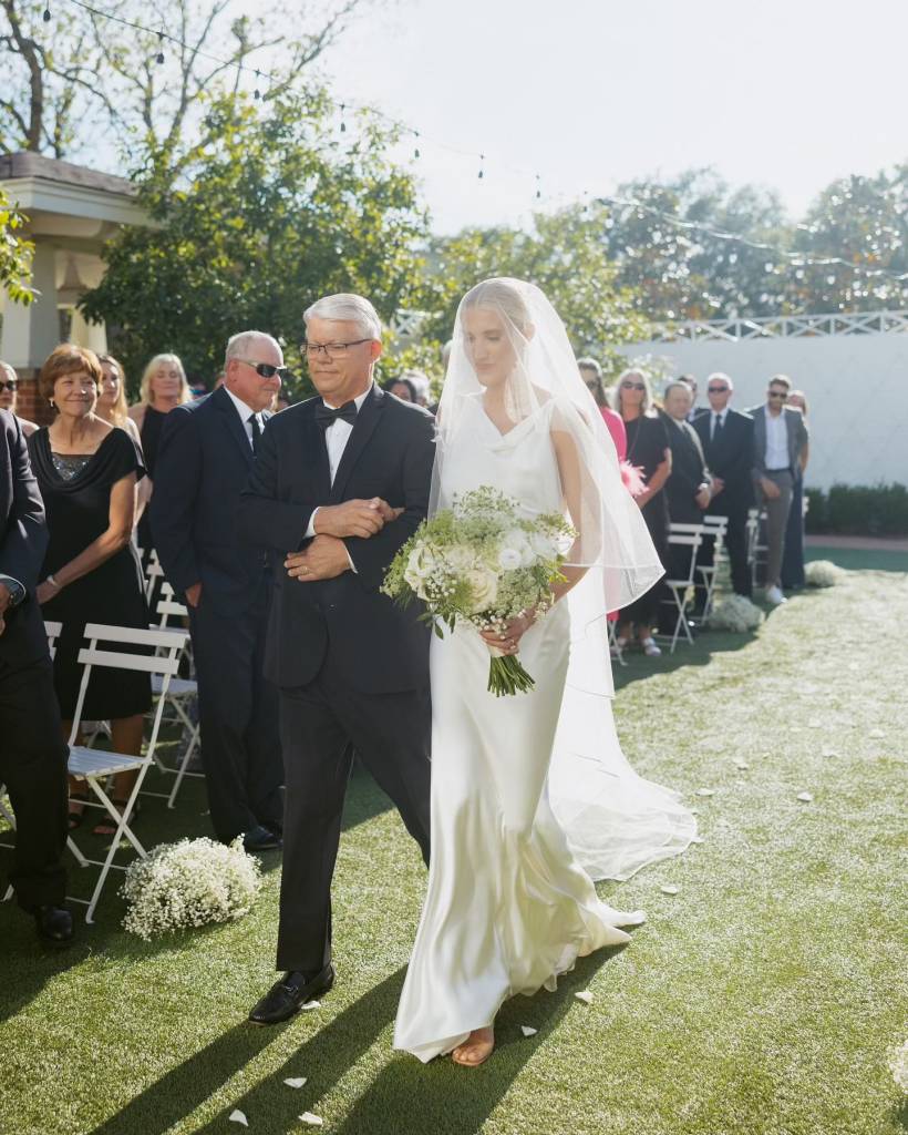 ⁠Kerri looked angelic walking down the aisle. Sporting a sleek bun under her veil and natural glam, she took everyone’s